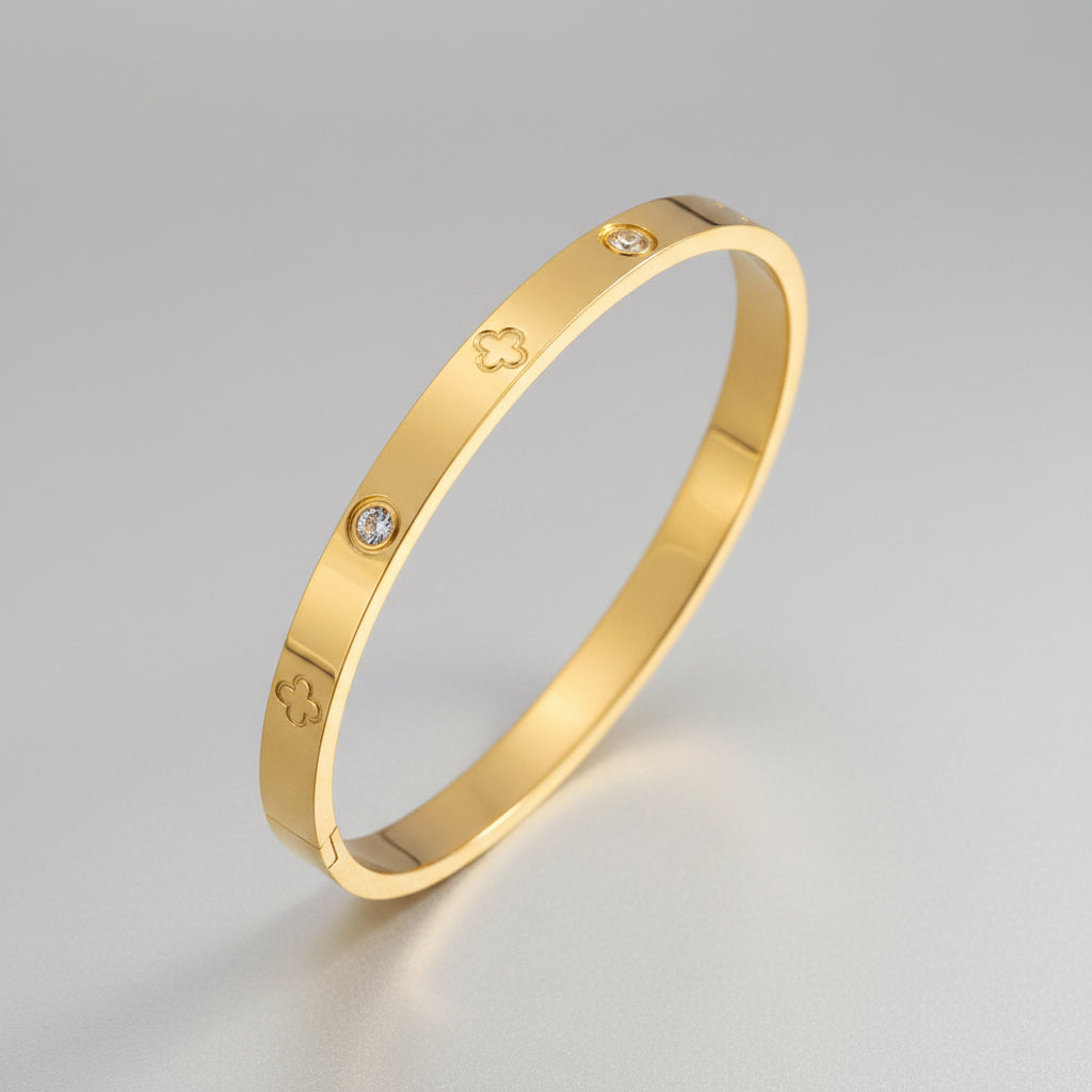 Gold bracelet with diamond accents on a gray surface